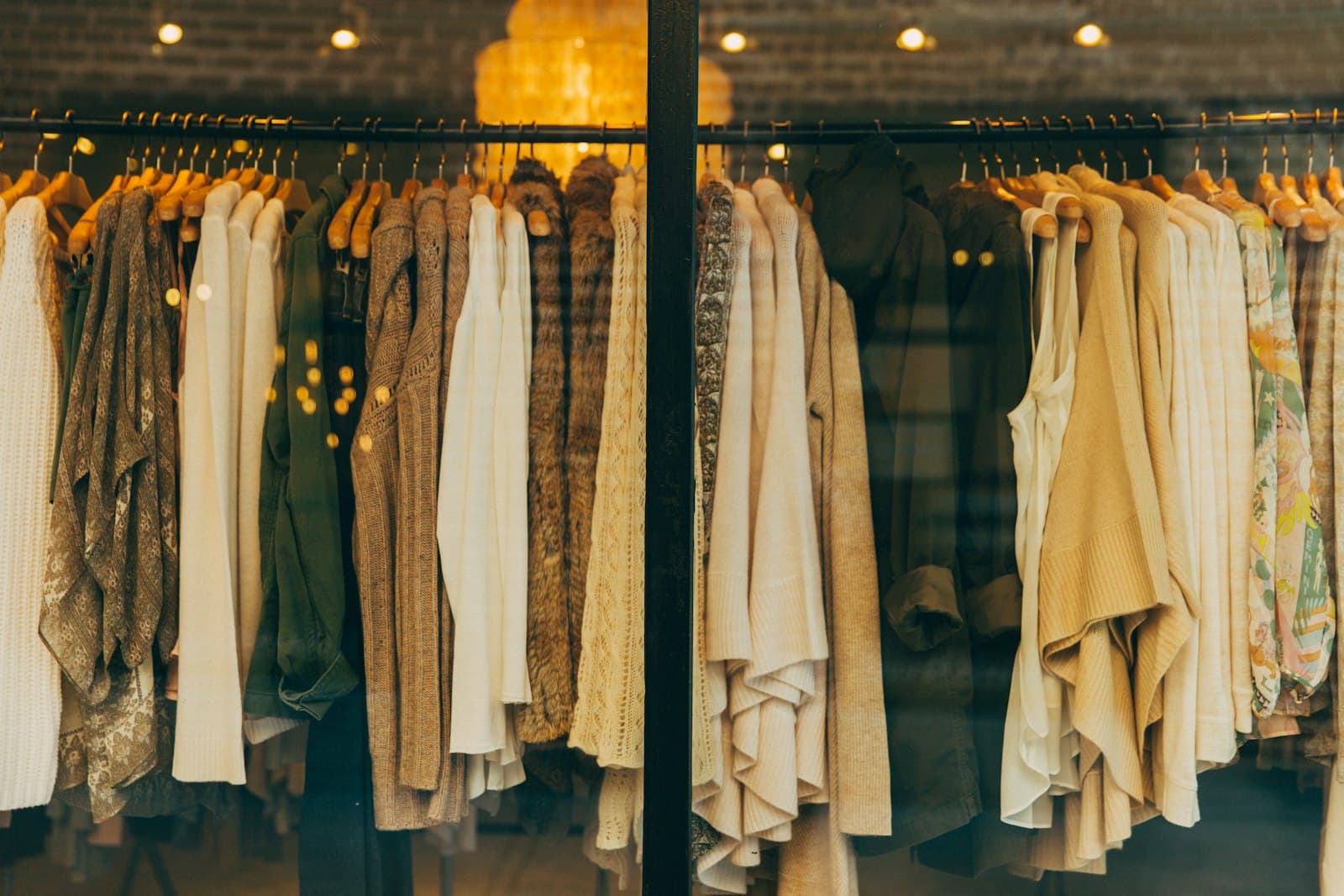 Couture garments in cream and gold hanging in an atelier window